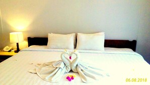A hotel room with a neatly made bed, a bedside lamp, and a telephone on the nightstand. - Dhyanapura City Hotel (Mengwi)