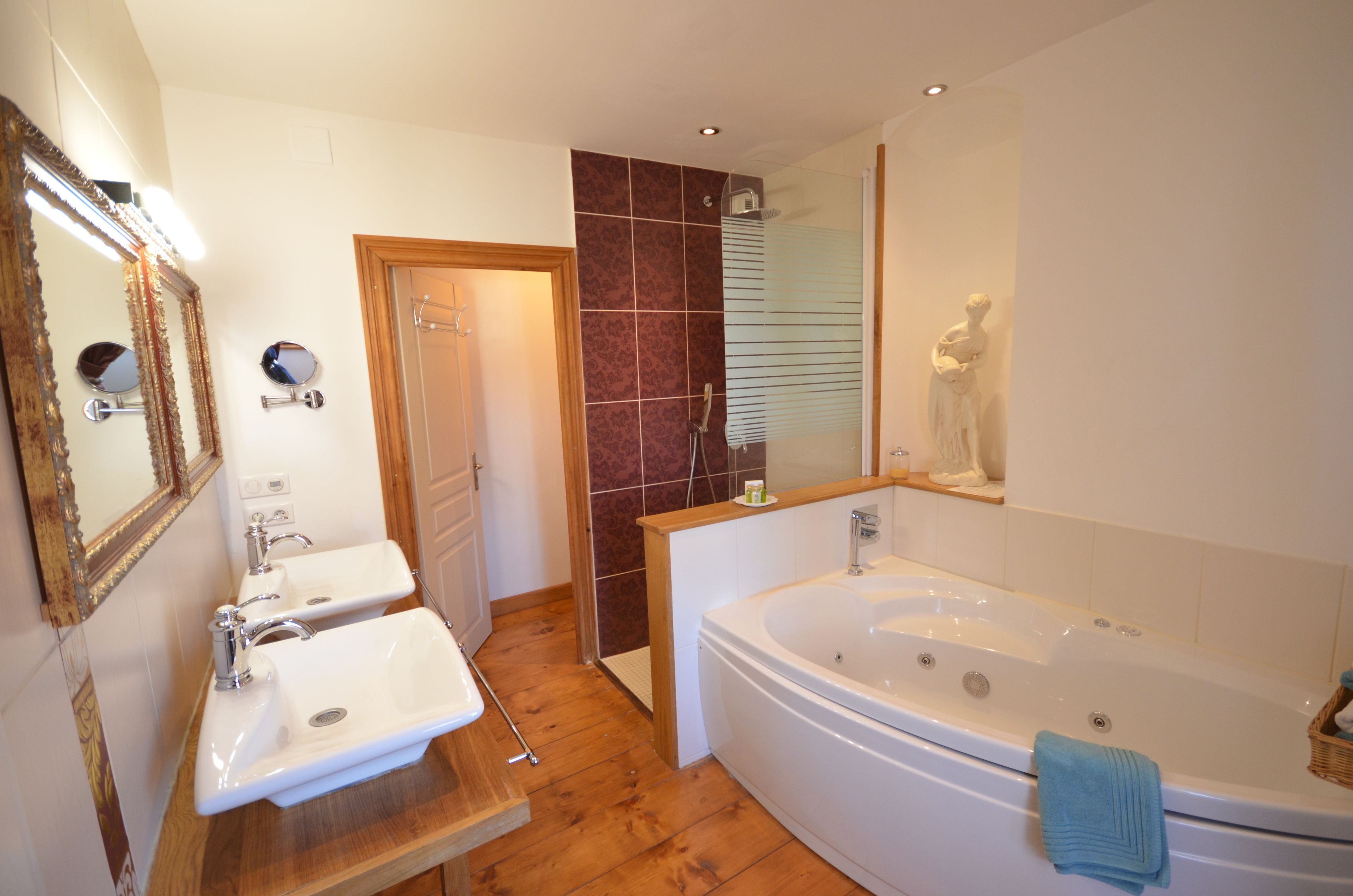 A bathroom with two sinks, a bathtub, and a shower.