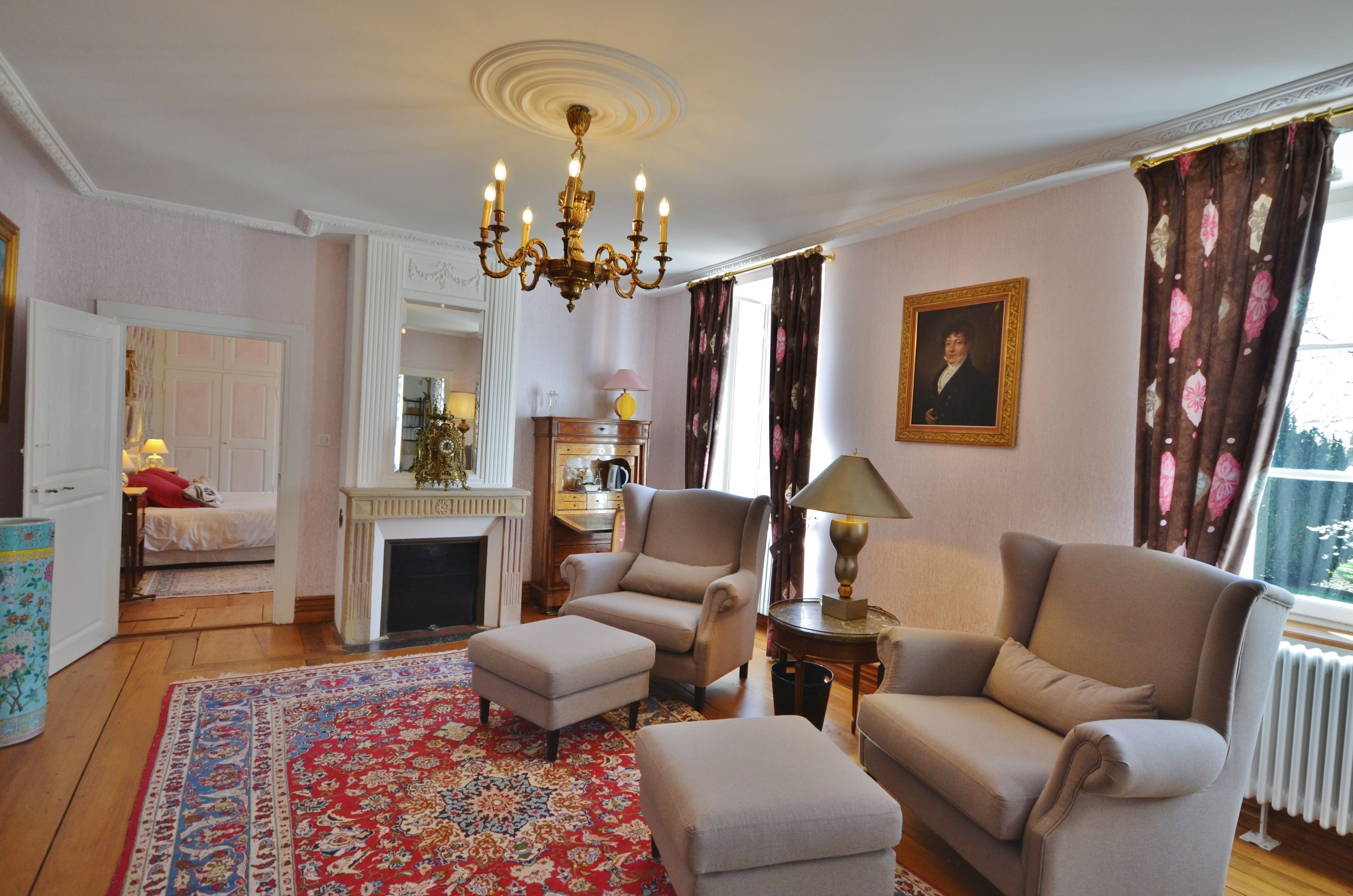 A living room with a chandelier, a fireplace, a sofa, and a patterned rug.