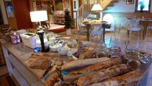 A buffet with various breads, cheeses, and condiments. - Hotel Panoramic Village - La Grave (La Grave)