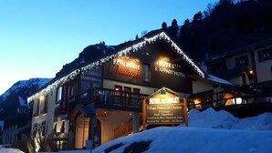 A hotel with a sign indicating it offers a chalet experience, a ski resort, and a location called Village Piéton de Chalets. - Hotel Panoramic Village - La Grave (La Grave)