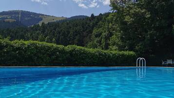 Una piscina al aire libre, tumbonas