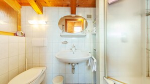 A bathroom with a toilet, sink, and mirror. - Haus Hubertus (Reit im Winkl)