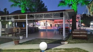 An outdoor patio area with seating and a covered section, likely part of a hotel or resort. - New Iday Hotel (Kusadasi)