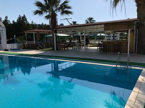 A swimming pool with a covered seating area, a bar, and a lifeguard stand. - New Iday Hotel (Kusadasi)