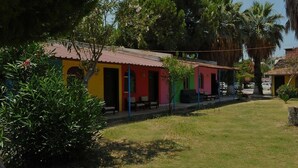 A row of colorful buildings with a grassy area in front. - New Iday Hotel (Kusadasi)