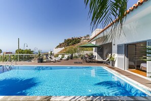 Una piscina al aire libre, tumbonas