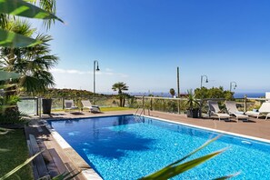 Una piscina al aire libre, tumbonas