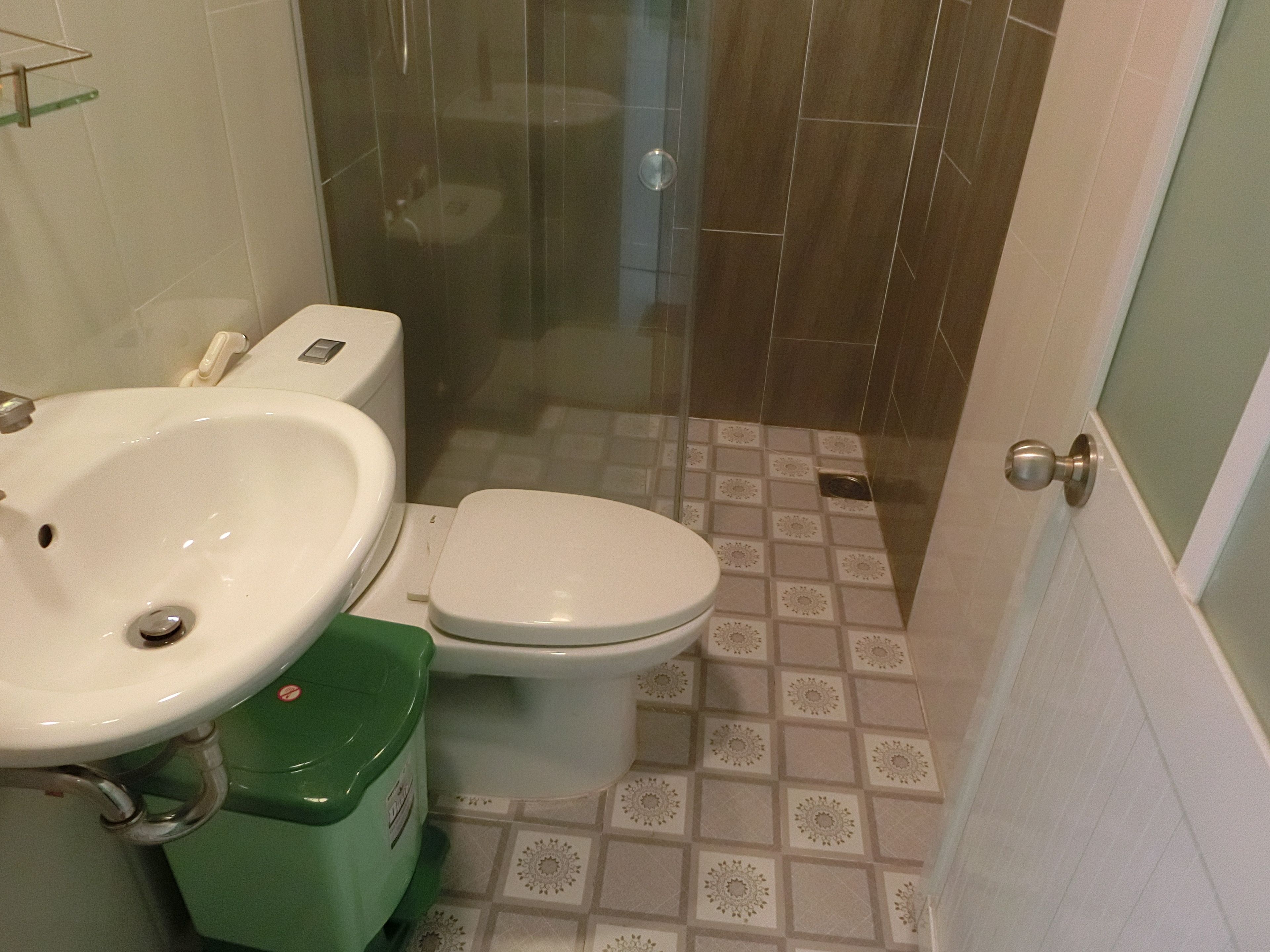 A bathroom with a sink, toilet, and shower area.