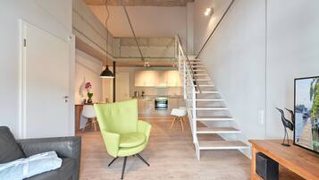 A modern living space with a staircase, a dining area, and a kitchen.