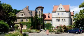 A historic building with a tower, stone facade, and red-tiled roof. - Schloss Herberge Hohenerxleben (Stassfurt)
