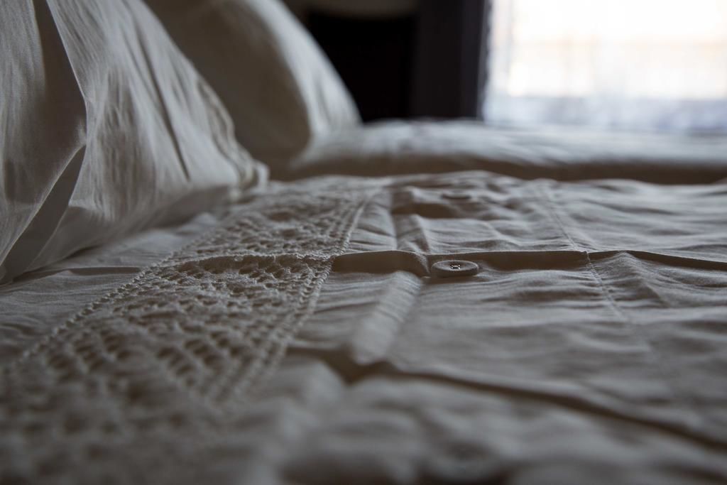 A bed with a lace bedspread and a button detail.
