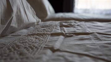 A bed with a lace bedspread and a button detail.