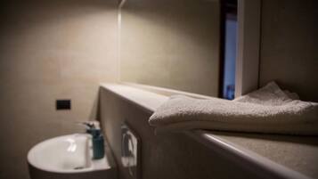 Une salle de bain avec un lavabo, un miroir et une serviette.