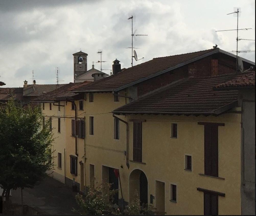 A row of traditional buildings with flat roofs and multiple antennas, suggesting a residential area.