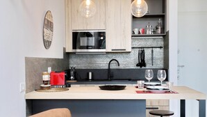 Una cocina moderna con una isla central, microondas y cafetera.