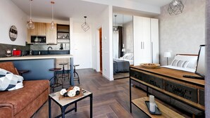 Un espacio habitable moderno con cocina, comedor y un dormitorio.