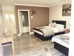 A bedroom with a bed, bedside tables, a wardrobe, and a door leading to a bathroom. - The Bay Horse Accommodation (Goole)