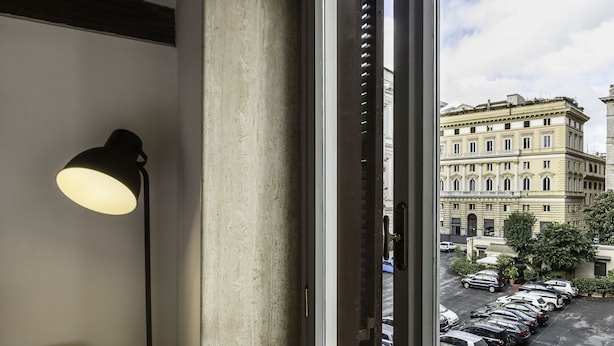 A window with a view of a parking lot and buildings. - Luxury Flat in the Center of Rome (Rome)