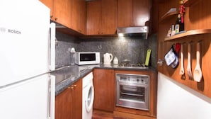 A kitchen with wooden cabinets, a Bosch refrigerator, a microwave, a washing machine, and a built-in oven. - Superbe penthouse to Piazza Navona (Rome)
