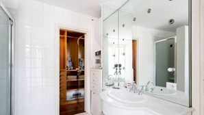 A modern bathroom with a large mirror, a white sink, and a walk-in closet. - Superbe penthouse to Piazza Navona (Rome)