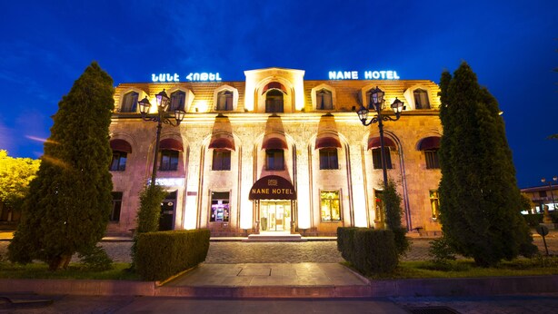 A historic building with a prominent entrance, arched windows, and a sign reading "Nane Hotel". - Nane Hotel (Gyumri)