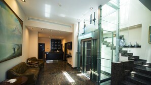 A lobby with a reception desk, seating area, and a staircase. - Nane Hotel (Gyumri)