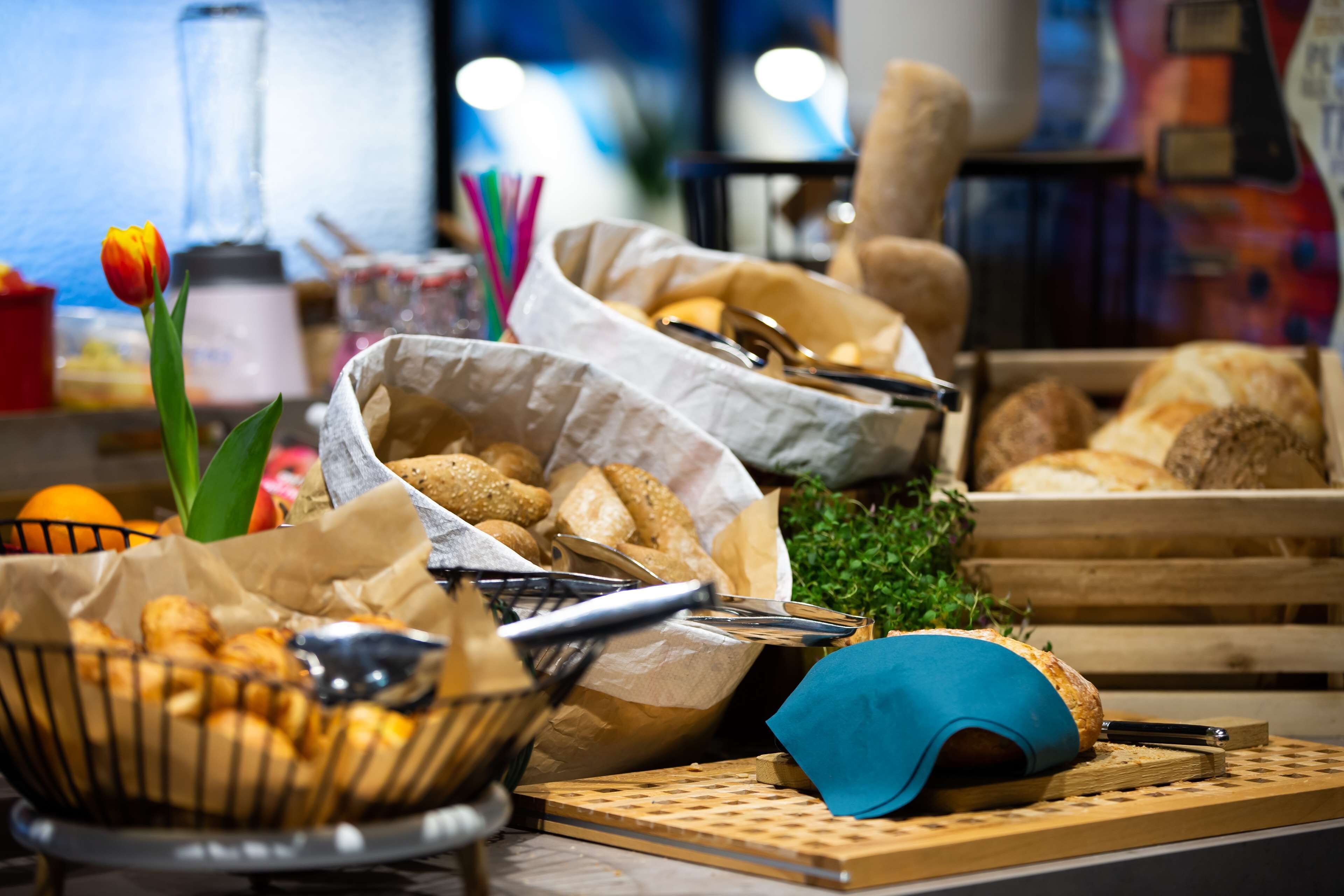 Un buffet proposant une variété de plats, notamment du pain, des pâtisseries et un saladier de fruits.