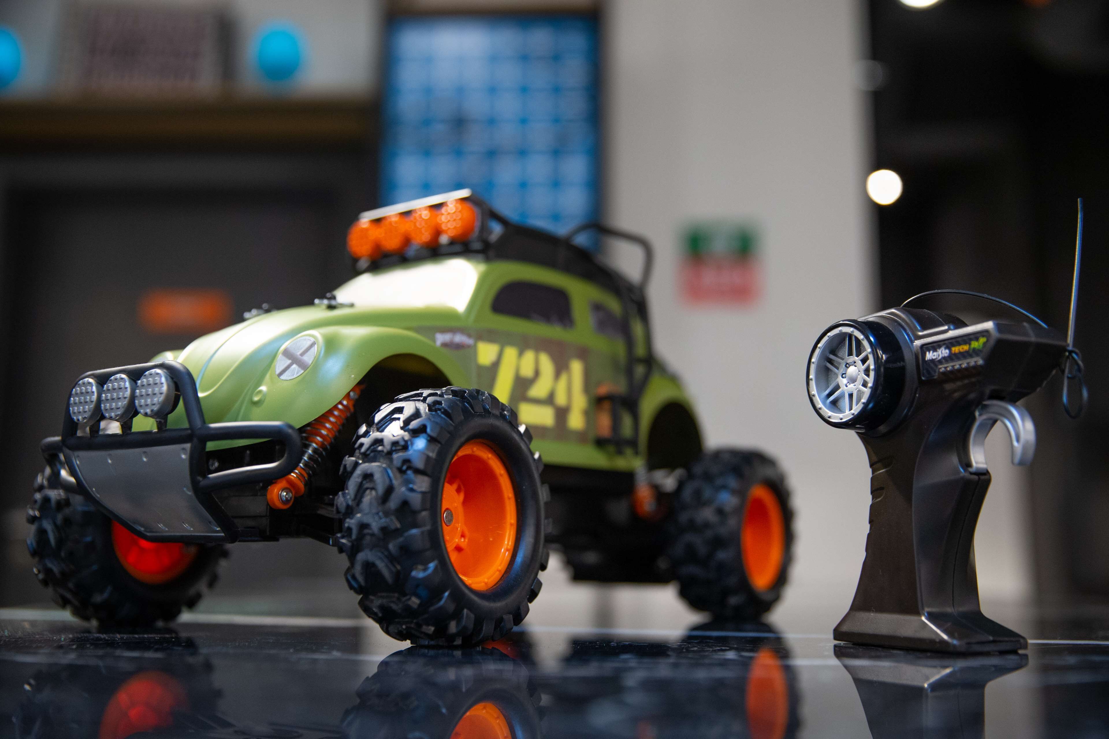 A toy vehicle with large tires and a light bar on a stand.