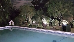 A nighttime pool area with a clear view of the sky and surrounding vegetation. - On-the-Summit Lodge & Conference Venue (East London)