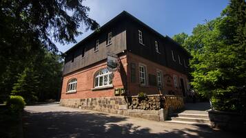 A two-story building with a brick facade and wooden upper levels, featuring arched windows and a stone foundation.