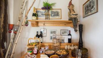 A wooden table with various food items, bottles, and a decorative figure.