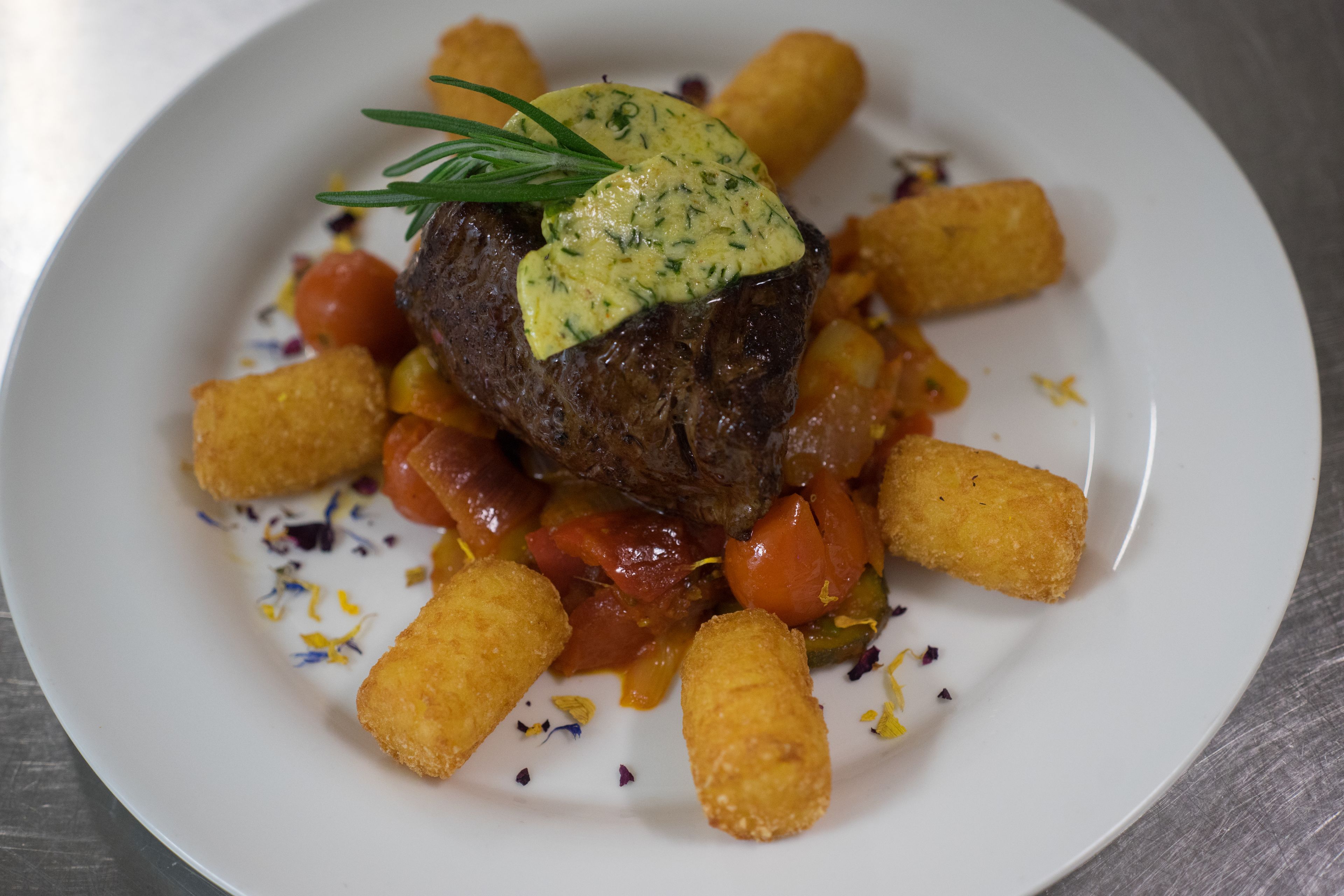 Un plato de comida con carne, verduras y productos empanizados.