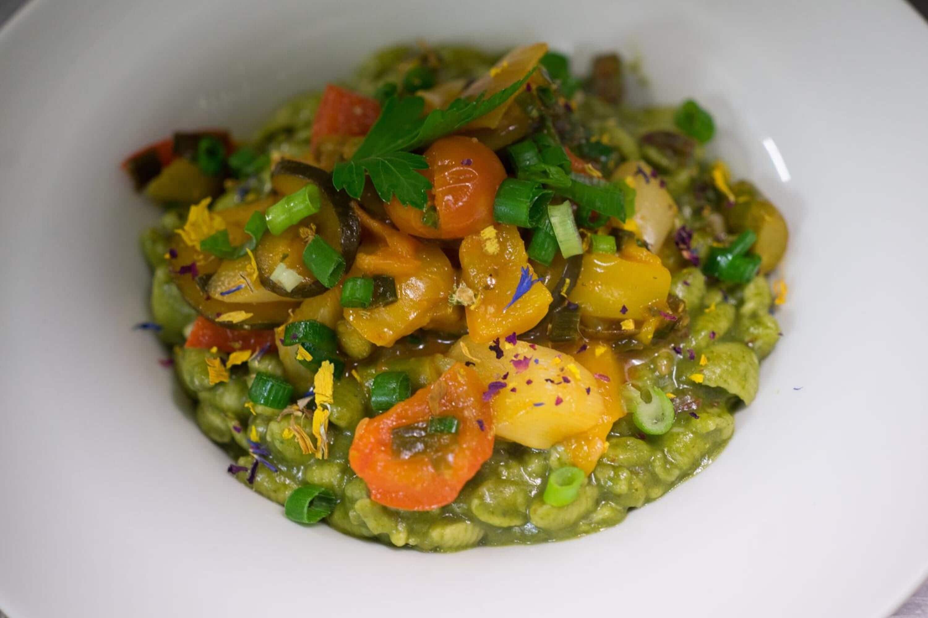 Un tazón de comida con diversas verduras y guarniciones.