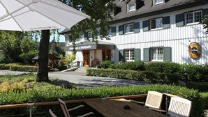 Ein traditionelles Gebäude mit einem Schild, auf dem 'Caféhaus im Waldpark' steht.