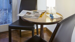 Un tavolo da pranzo con una rivista, una lampada e un bicchiere d'acqua.