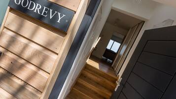 A wooden staircase with a black door and a sign that reads "GODREY".