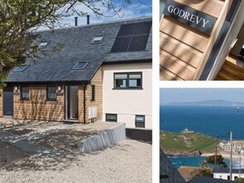 Una casa moderna con techo inclinado, paneles solares y vista al mar.