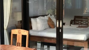 A room with a bed, a wooden chair, and a table. - The Hidden Bali Inn (Ubud)