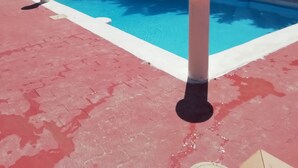 A swimming pool with a slide, surrounded by a red deck and white bollards. - B&B Nicole (Palma di Montechiaro)