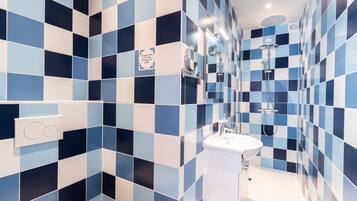 A bathroom with checkered blue and white tiles, a white sink, and a shower.