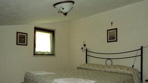 Un dormitorio con una cama, una ventana y dos cuadros colgados en la pared.