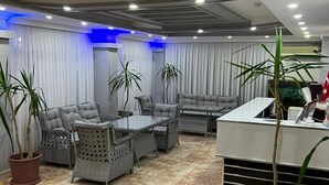 A modern living room with a sofa set, a coffee table, and potted plants. - Kartel Hotel (Didim)