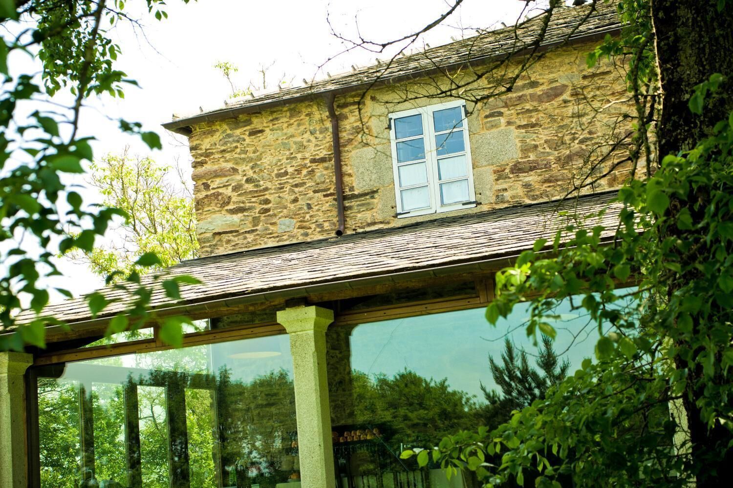A stone building with a large window and a covered porch.