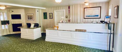 A reception area with a counter, a desk, and a door.