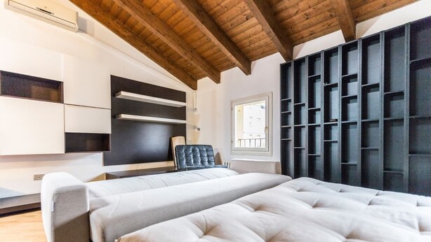 Ein modernes Schlafzimmer mit einem großen Bett, Einbauschränken und einem Fenster.