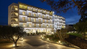 Un hôtel à plusieurs étages au design moderne, doté d’une allée incurvée et d’espaces extérieurs bien éclairés.