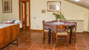 Comedor con una mesa dispuesta para cuatro, un banco de madera y un tragaluz en el techo.