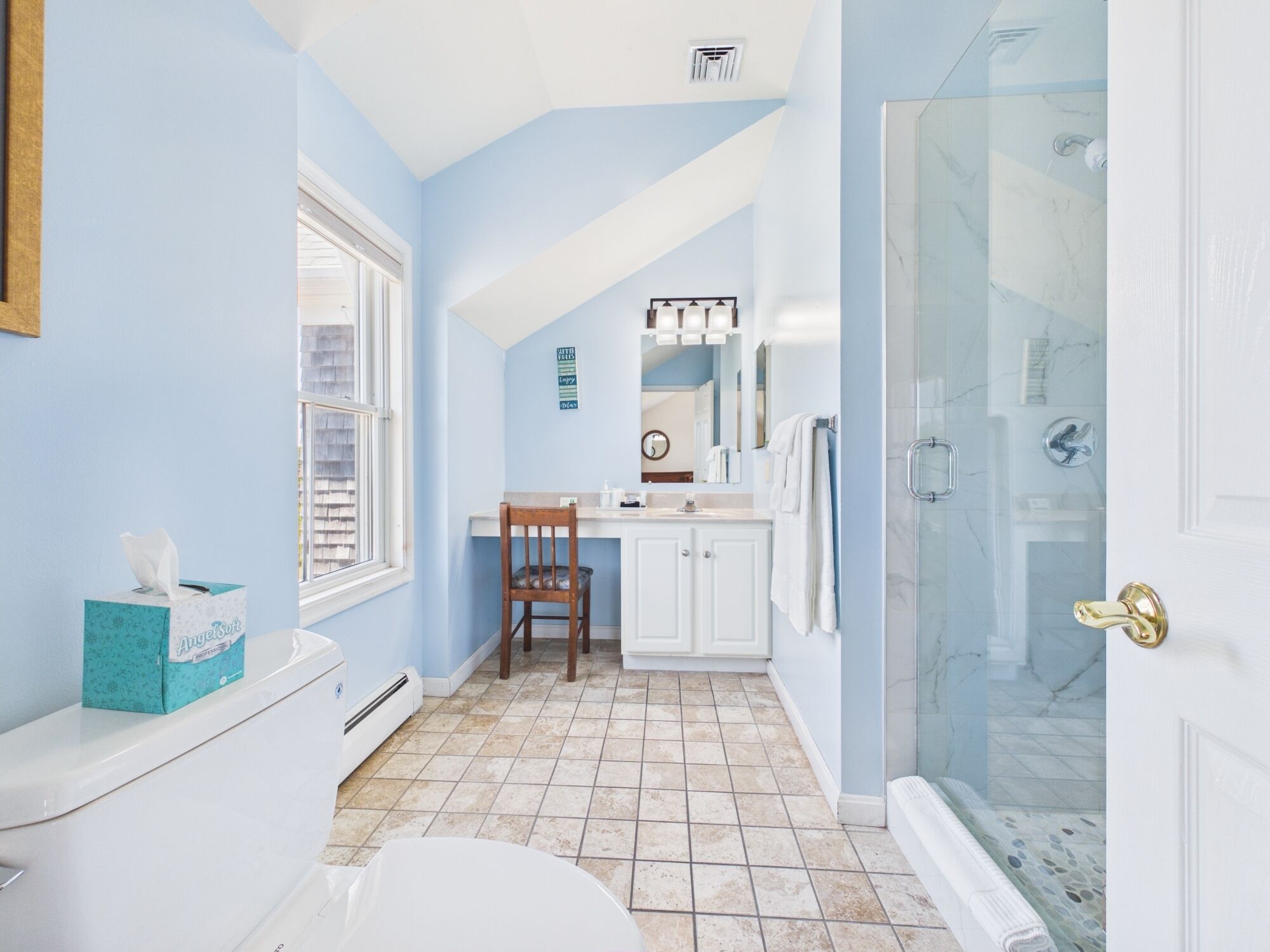 Une salle de bain comprenant des toilettes, un lavabo et un espace douche.