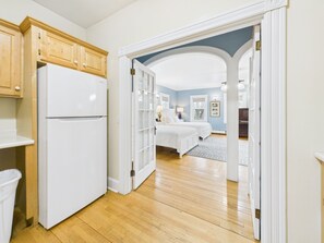 Um quarto com uma cama, mesa de cabeceira, abajur e janela.